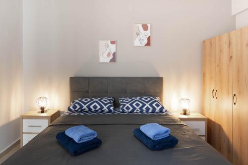 a bedroom with a large bed with blue pillows at Athens Luxuery 3BR in Athens
