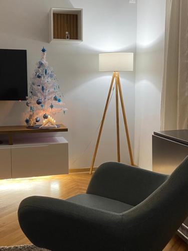 uma sala de estar com uma árvore de Natal e uma cadeira em Dorotea Lux em Belgrado