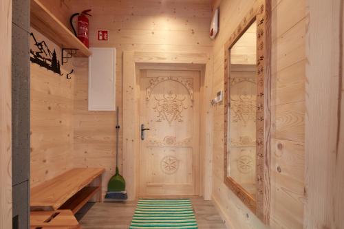 a hallway with a wooden door and a green rug at Domki 4 Turnie in Ząb