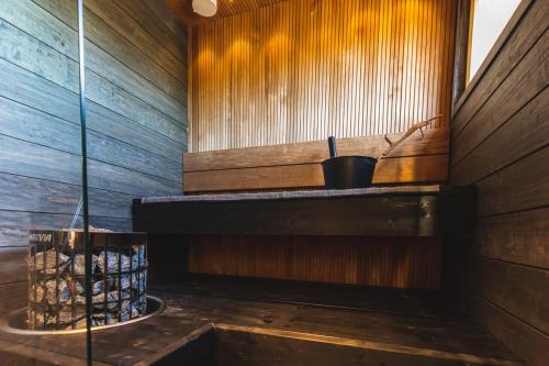 a sauna with a wooden wall and a window at Levi Sky Igloo in Kittilä