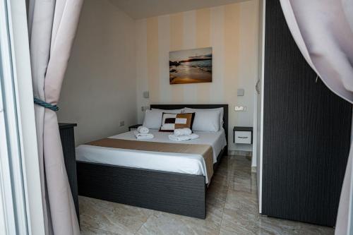 a small bedroom with a bed in a room at The Willows Penthouses with Jacuzzi in Għajn il-Kbira