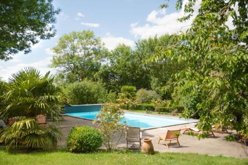 einen Pool in einem Garten mit Bäumen in der Unterkunft Moulin de Tessé in Flexanville