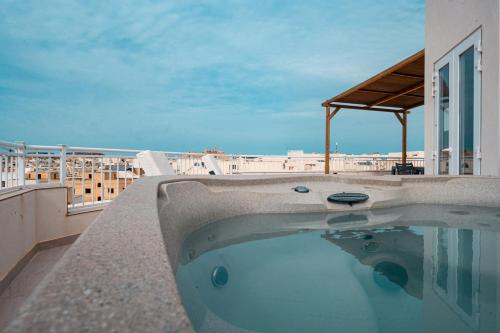 a swimming pool on the roof of a building at The Willows Penthouses with Jacuzzi in Għajn il-Kbira