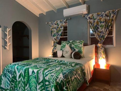 1 dormitorio con 1 cama con edredón verde y blanco en Story Villa 1 Bedroom with Ocean & Mountain View, en Canaries