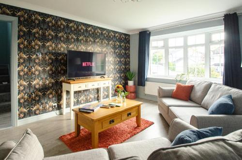 Bamber BridgeにあるHuntsfield House- Stunning Modern 4 Bedroom House Suitable for Work and Leisure Staysのソファとテレビのあるリビングルーム