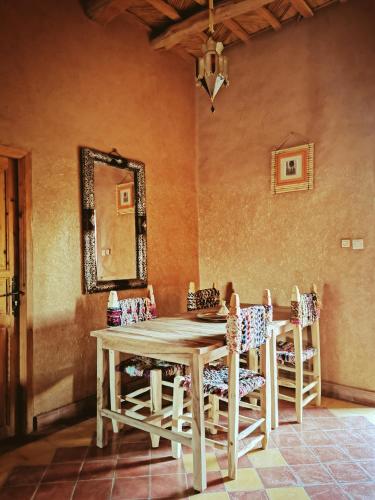a dining room table with chairs and a mirror at Maison d'hôte tamatart - Homestay in Kalaat MGouna