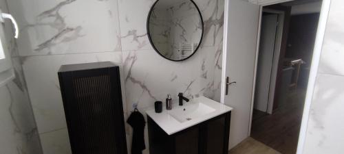 łazienka z umywalką i lustrem na ścianie w obiekcie Au Terrier w mieście Bettancourt-la-Ferrée