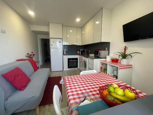 uma cozinha e uma sala de estar com uma mesa com uma taça de fruta em LOFT AS CASETAS PEREGRINOS em Rosal