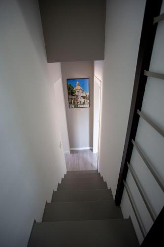 a stairway with a picture hanging on the wall at Domus 25 in Catania