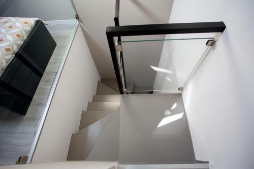 a stairwell with a glass railing and a bed at Domus 25 in Catania
