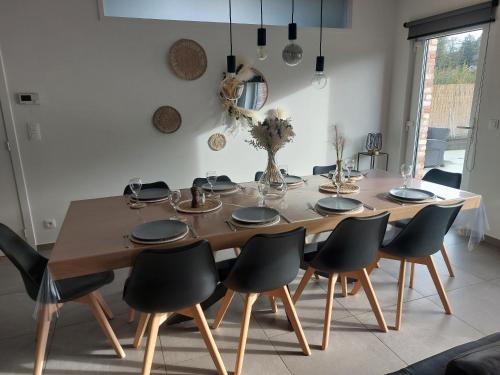 una mesa de comedor con sillas negras alrededor en Gite Comme chez soi, en Spa