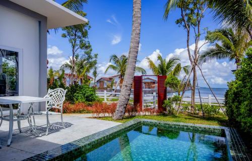 een villa met een zwembad en de oceaan bij Koh Apikjun Resort in Kaoh Sdach