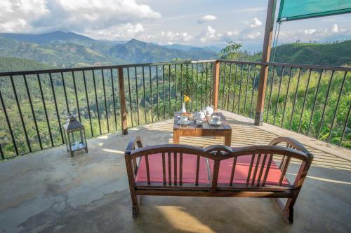a balcony with a table and a view of mountains at Madulkelle Tea and Eco Lodge in Kandy
