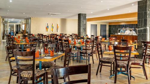 uma sala de jantar com mesas e cadeiras num restaurante em African Sky Ermelo Inn em Ermelo