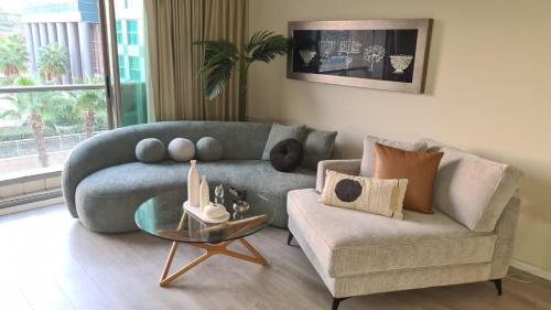a living room with a blue couch and a chair at Haigen 4 in Herzliya