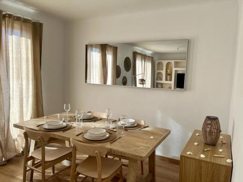 - une table à manger avec des chaises et un miroir dans l'établissement Appartement Plage Prado avec parking, à Marseille