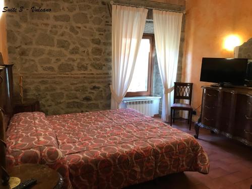 1 dormitorio con cama, ventana y TV en Albergo Diffuso Locanda Specchio Di Diana en Nemi