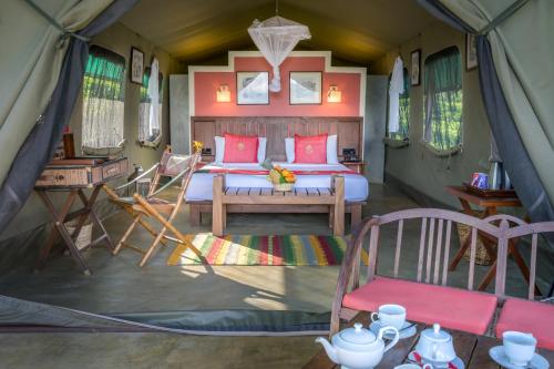 a bedroom in a tent with a bed and a table at Madulkelle Tea and Eco Lodge in Kandy