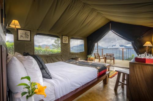 a bedroom with a bed in a tent at Madulkelle Tea and Eco Lodge in Kandy