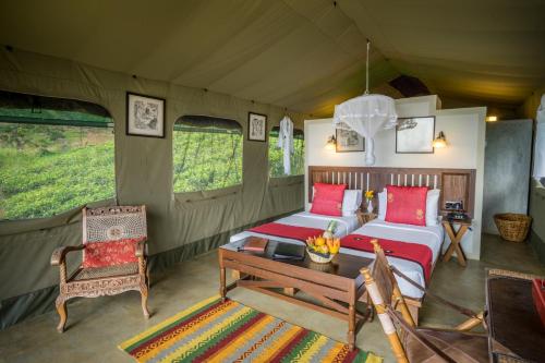 a room with a bed and a table and chairs at Madulkelle Tea and Eco Lodge in Kandy