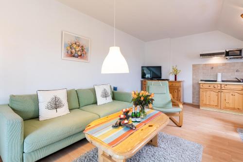 a living room with a green couch and a coffee table at Pension Haus Anneliese in Ueckeritz