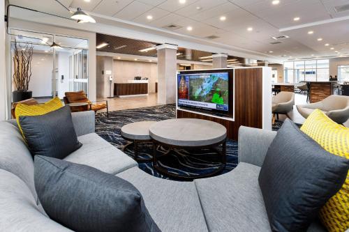 a lobby with a couch and a table and a tv at Courtyard by Marriott Pensacola I-10 West in Pensacola