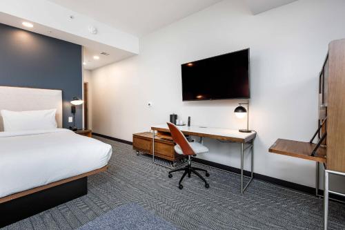 um quarto de hotel com uma cama e uma secretária com um computador em Courtyard by Marriott Pensacola West em Pensacola