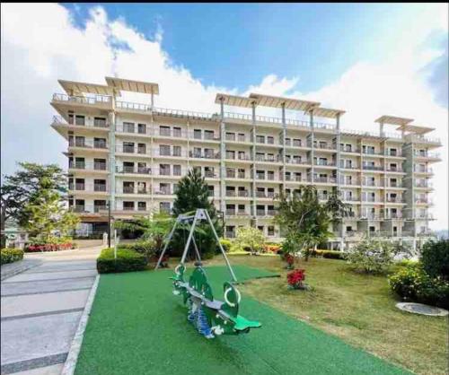 un parque infantil frente a un gran edificio en YourHomeAway,LuxFlat at BristleRidge Baguio, en Baguio