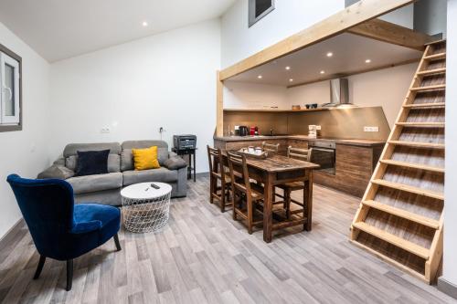 a living room with a couch and a table and a kitchen at L'Epinette - Gîte de groupe et salle de réception in Allevard