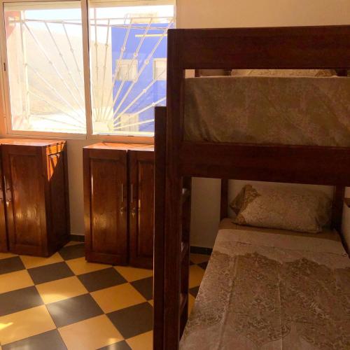 a bedroom with two bunk beds and a checkered floor at TOODA House in Imsouane