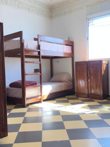 two bunk beds in a room with a checkered floor at TOODA House in Imsouane