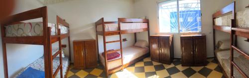 a room with four bunk beds and a window at TOODA House in Imsouane