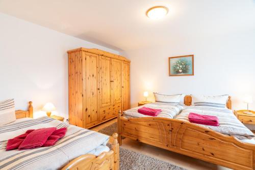 2 camas individuales en un dormitorio con armarios de madera en Pension Haus Anneliese en Ueckeritz