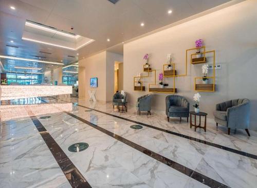 a lobby with chairs and tables in a building at Orbi City Apartments in Batumi