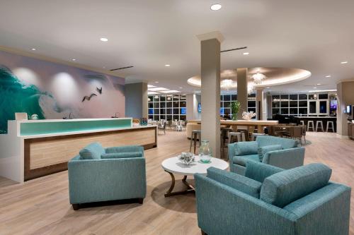 a lobby with blue chairs and a bar at SpringHill Suites by Marriott New Smyrna Beach in New Smyrna Beach