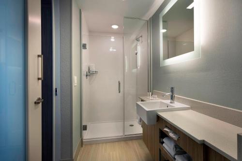 y baño con lavabo y ducha con espejo. en SpringHill Suites by Marriott New Smyrna Beach en New Smyrna Beach