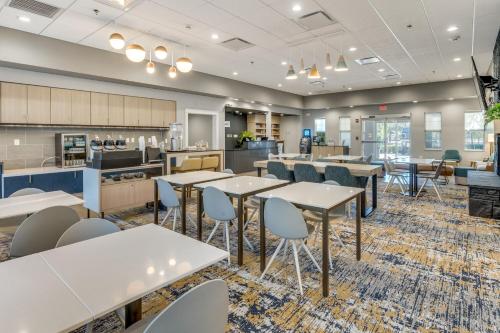 a cafeteria with tables and chairs and a kitchen at TownePlace Suites Dallas Arlington North in Arlington