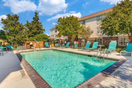 a swimming pool with chairs and a building at TownePlace Suites Dallas Arlington North in Arlington