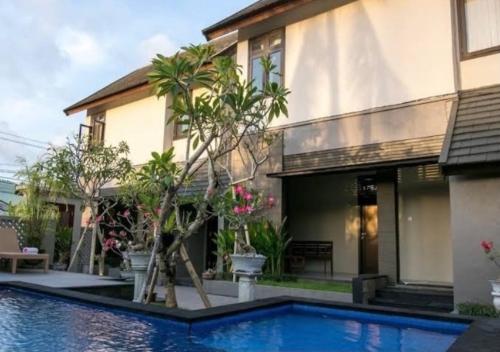 a villa with a swimming pool in front of a house at Meilds Property Kuta in Kuta