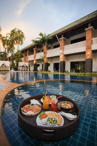 a tray of food on a table in a swimming pool at ETK Patong Resort in Patong Beach
