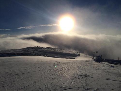a snow covered mountain with the sun in the sky at Feriested i Tørberget in Tørberget