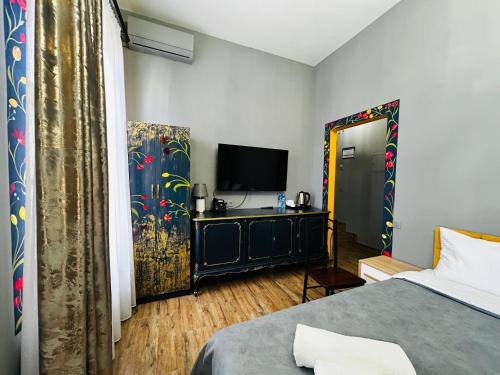 a bedroom with a bed and a television in a room at Hotel Zerta Old Tbilisi in Tbilisi City