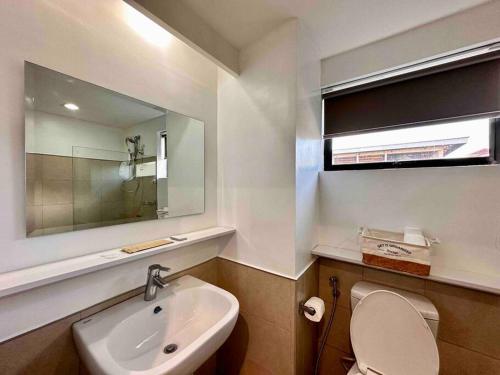 uma casa de banho com um lavatório, um WC e um espelho. em Hotel Living,The Persimmon double beds 4pax (904) em Cebu