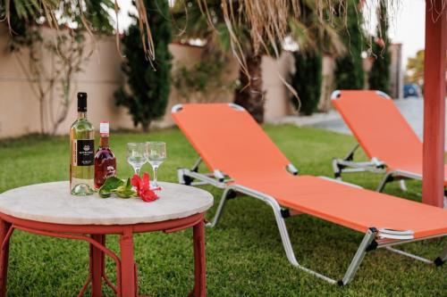 una mesa con una botella de vino y dos sillas en ATLAS Villa, en Kástro Tornéze