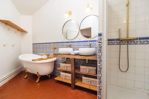 a bathroom with a tub and two sinks and a shower at LE GRAND FRANC gite cosy proche tous commerces in Tonnay-Charente