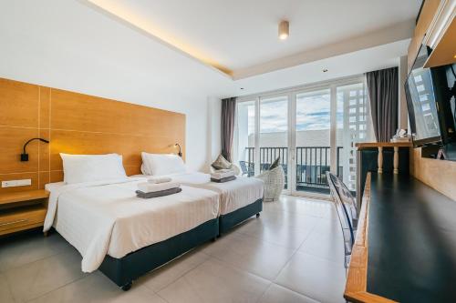 Un dormitorio con una cama grande y un balcón. en Vivace Hotel, en Kamala Beach