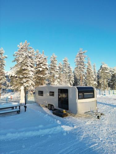 a camper parked in a field in the snow at Santa`s luxury trailer in Rovaniemi
