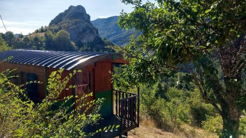 a train cabin with a mountain in the background at Les ROULOTTINS in Briançonnet
