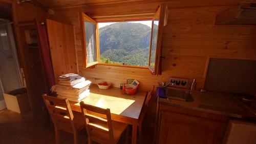 a small kitchen with a table and a window at Les ROULOTTINS in Briançonnet