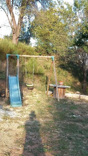 a playground with a swing and a bench at Les ROULOTTINS in Briançonnet